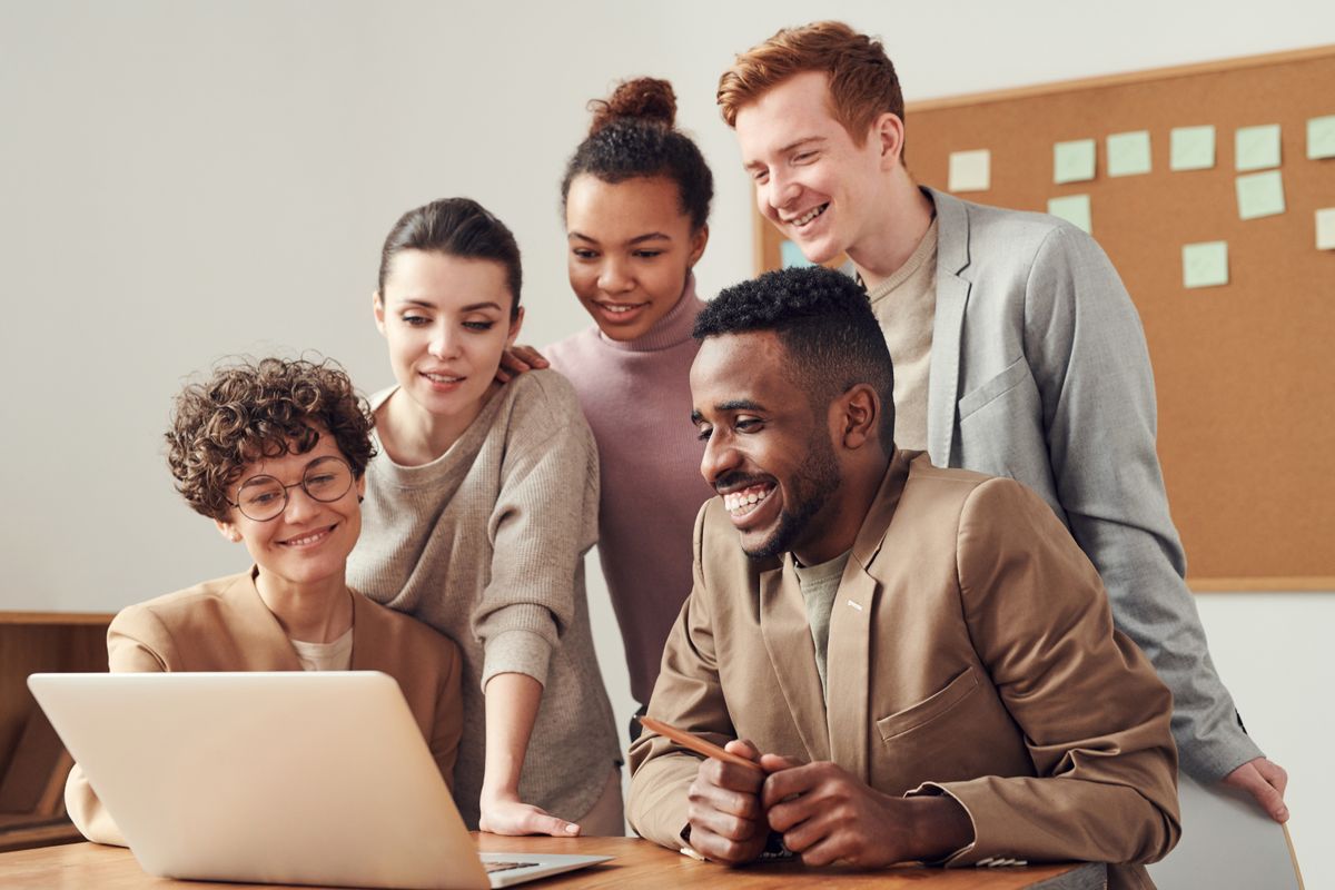 Team discussing SaaS subscription plans with laptops in a modern office